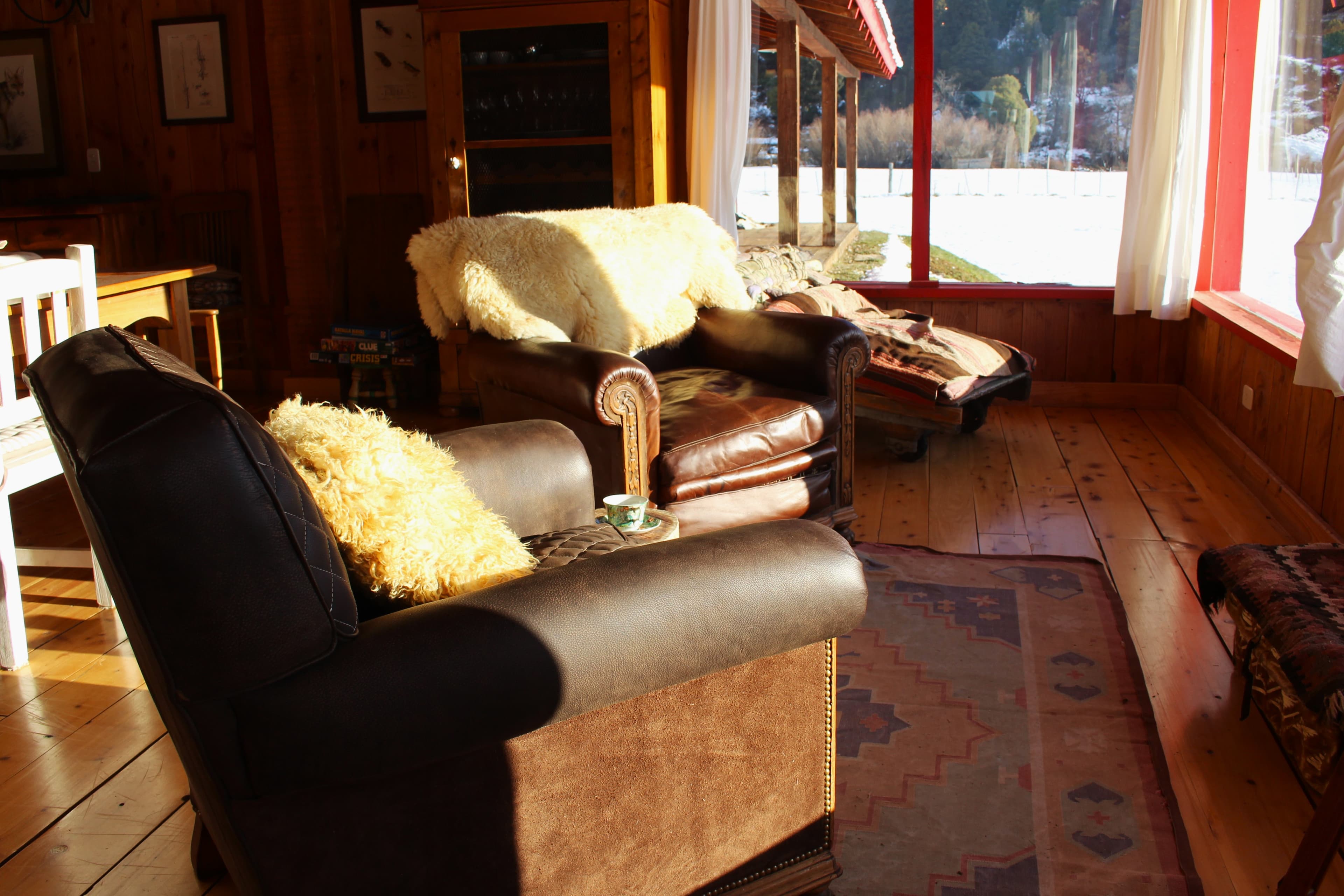 Facilities of La Pilarica Lodge with three cars and snowy mountains in the background